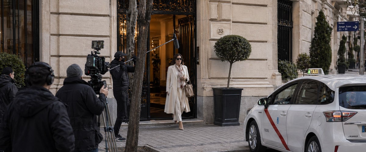 Rodaje de una actriz saliendo de un portal de un edificio elegante en Madrid